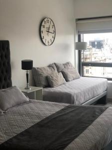 a bedroom with a bed and a clock on the wall at Las Naciones 1710 in Buenos Aires