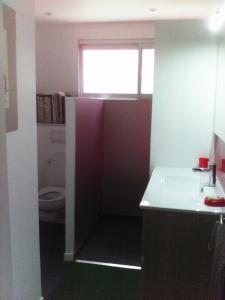 a small bathroom with a sink and a toilet at Alain in Noumea