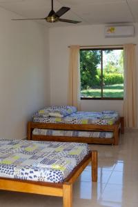 two beds in a room with a window at VILLA SAMARI 4 Casa campestre con piscina privada in Girardot