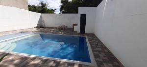 - une piscine en face d'un mur blanc dans l'établissement VILLA SAMARI 4 Casa campestre con piscina privada, à Girardot