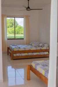 1 Schlafzimmer mit 2 Betten und einem Fenster in der Unterkunft VILLA SAMARI 4 Casa campestre con piscina privada in Girardot