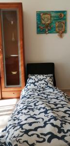 a bed with a blue and white comforter in a bedroom at Apartamento- csantos in Olhos de Água