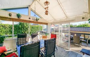 a screened porch with chairs and a chandelier at Beautiful Home In Gteborg With Wifi And 4 Bedrooms in Gothenburg