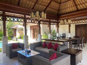 an outdoor living room with a couch and a table at Jimbaran BeachStroll Villa (2BR) in Jimbaran