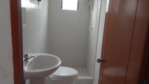 Łazienka z białą toaletą i umywalką w obiekcie Qosqollay Plaza de armas w Cuzco
