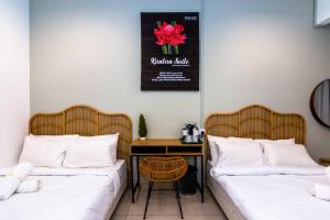 two beds in a room with a desk and a table at The Best Hotel in Bayan Lepas - THE LOV PENANG in Bayan Lepas