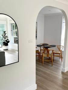 uma sala de jantar com uma mesa e um espelho em Som House 1 em Shoal Bay