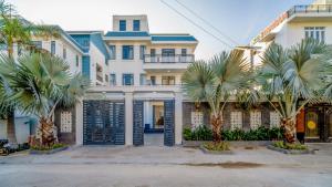 une grande maison avec des palmiers devant dans l'établissement B2-21 Hoàng My Villages, à Vung Tau