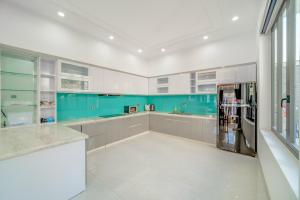 a kitchen with white cabinets and a blue wall at B2-21 Hoàng My Villages in Vung Tau