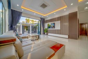 a living room with a white couch and a large window at B2-21 Hoàng My Villages in Vung Tau