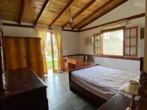 1 dormitorio con 1 cama, escritorio y ventanas en Casa de campo con piscina en Asia, en Asia