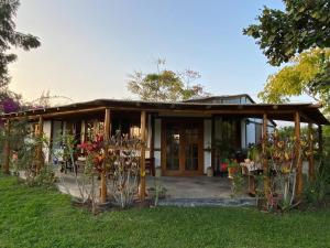 a house with a porch with flowers in the yard at Casa de campo con piscina en Asia in Asia