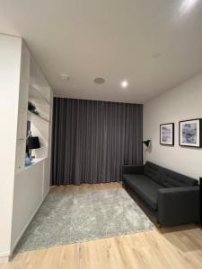 a living room with a couch and a window at LHR Apartments in London