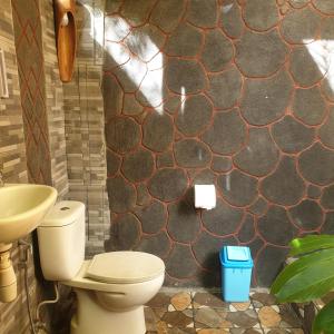 a bathroom with a toilet and a sink at Second Home Bungalows in Tetebatu