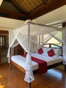Bett mit Baldachin in einem Zimmer in der Unterkunft Jimbaran BeachStroll Villa (3BR) in Jimbaran