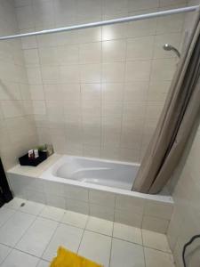 eine weiße Badewanne im Bad mit Dusche in der Unterkunft شقة الاحلام in King Abdullah Economic City