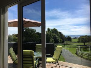 un patio con mesa, sillas y sombrilla en Shearer's Quarters, en Rotorua