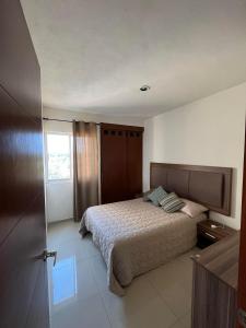 um quarto com uma cama e uma janela em Casa Flamingos em Bucerías