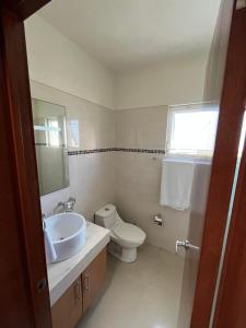 uma casa de banho com um lavatório, um WC e um espelho. em Casa Flamingos em Bucerías