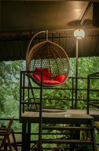 a chair with a red cushion in a basket at Lodge Phang nga boutique in Ban Khaek