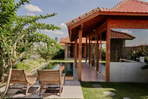 ein Haus mit einem Pool und zwei Stühlen in der Unterkunft Bruann Villa 3 Pererenan, Seseh, Canggu, amazing view, 2 bedroom in Mengwi