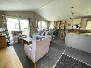 un soggiorno con divani e una cucina di Beautiful Lodge With Decking In Hunstanton At Manor Park Ref 23023w a Hunstanton