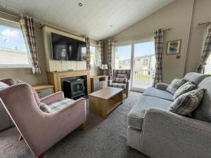 sala de estar con 2 sofás y chimenea en Beautiful Lodge With Decking In Hunstanton At Manor Park Ref 23023w, en Hunstanton