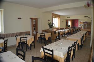 a dining room with tables and chairs with white tablecloths at Sempione Hotel Malpensa in Casorate Sempione