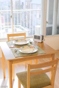 einem Holztisch mit einem Teller Essen und einem Modem in der Unterkunft NanEi Building in Kagoshima