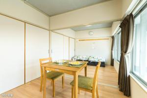 comedor con mesa, sillas y sofá en NanEi Building, en Kagoshima