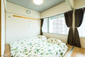 鹿兒島的住宿－NanEi Building，一间卧室设有一张床和一个窗口
