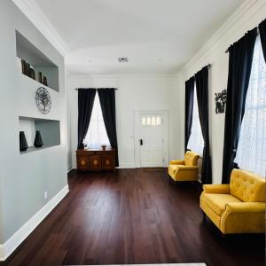 a living room with a yellow couch and wooden floors at Walk to French Quarter Canal Suite Guesthouse in New Orleans