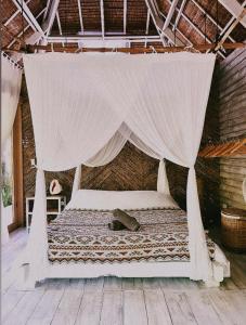 a bed in a room with a mosquito net at Secret Pool Villa Tuason Beach in General Luna