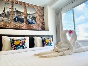 a swan made out of towels sitting on a bed at U Hatyai Hotel in Hat Yai