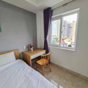 a bedroom with a bed and a desk and a window at ZEN BUILDING in Ho Chi Minh City