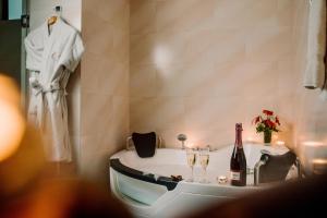 ein Badezimmer mit Badewanne und einer Flasche Wein in der Unterkunft Hotel Nobility in Lima
