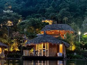 a small hut on the water at night at Jantara Resort and Restaurant in Ban Bang O