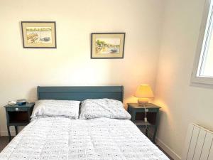 ein Schlafzimmer mit einem Bett und drei Bildern an der Wand in der Unterkunft Appartement La Forêt-Fouesnant, 2 pièces, 4 personnes - FR-1-481-146 in La Forêt-Fouesnant