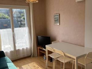 uma sala de estar com uma mesa e cadeiras e uma janela em Appartement Cabourg, 3 pièces, 4 personnes - FR-1-794-83 em Cabourg