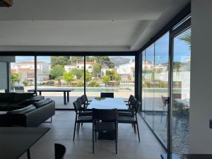 uma sala de estar com mesa e cadeiras em Villa de luxe avec amarre Rosas em Roses