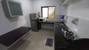 a small kitchen with a sink and a refrigerator at The Nest - Harmony Inn in Sangli