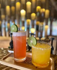 three cocktails sitting on a tray on a table at Jantara Resort and Restaurant in Ban Bang O +45 photos