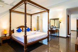 een slaapkamer met een hemelbed en een bureau bij Starloka Saba Bali Hotel in Blahbatu