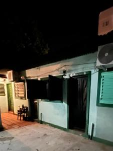 ein grünes Gebäude mit einer Tür und einer Bank davor in der Unterkunft Monoambiente F en Ctes Cap in Corrientes