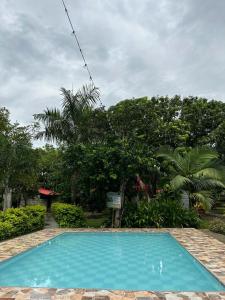 a blue swimming pool in a yard with trees at Cabaña Villa Mary-Aguachica in Aguachica