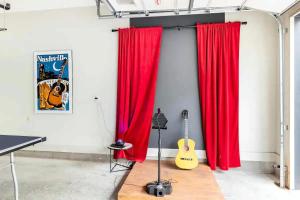 a room with red curtains and a guitar on a wall at Rooftop Skyline View - Karaoke Stage - 4 Bedroom in Nashville