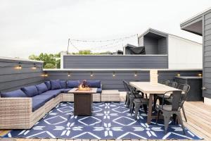a patio with a blue couch and a table and chairs at Rooftop Skyline View - Karaoke Stage - 4 Bedroom in Nashville