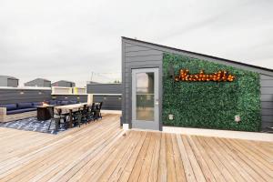 a building with a green wall with a table and chairs at Rooftop Skyline View - Karaoke Stage - 4 Bedroom in Nashville