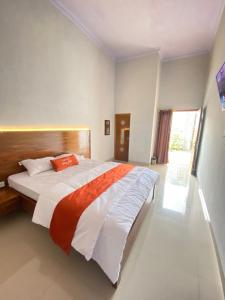 una camera con un grande letto con testiera in legno di Umyas Hotel Syariah a Nganjuk