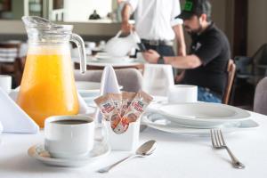 uma mesa com um jarro de sumo de laranja e uma chávena de café em MBM Red Sun Hotel em Monterrey